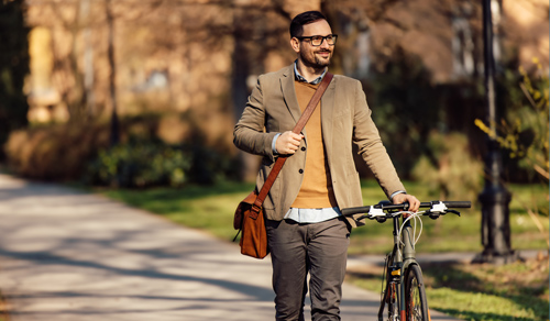 Biking and walking to work. Image of man walking his bike. 