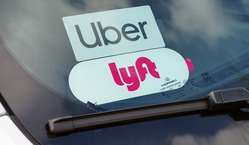 Image of cars windshield with an Uber and Lyft sticker. 