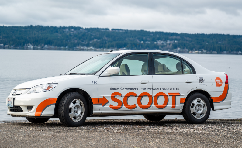white SCOOT car in front of a water background